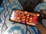 dua-orang-sedang-bermain-game-online-berunsur-judi-higgs_220803201246-183